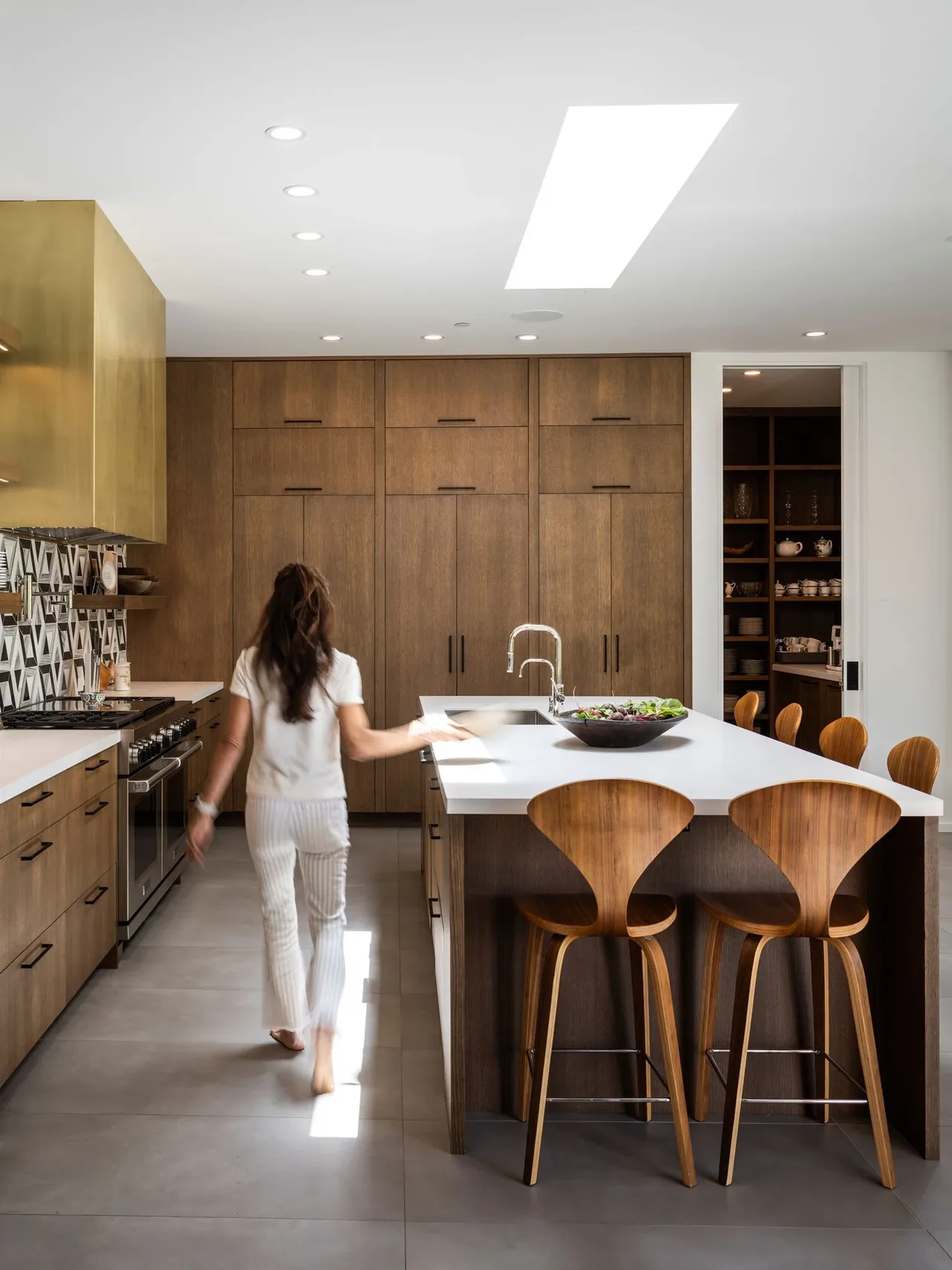 Kitchen with wooden cabinets, kitchen island with bar seating, and a skylight above.