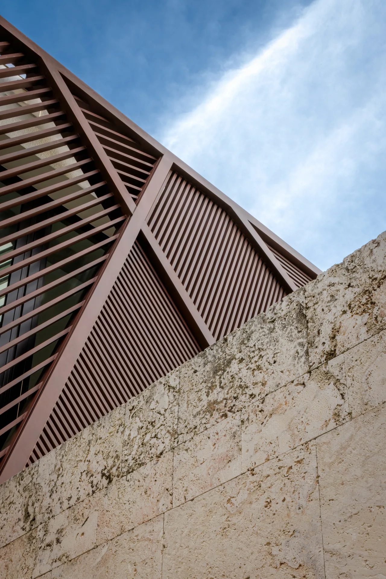 The Kiaora Residence features diagonal wood slats contrasted with textured stone exterior walls.
