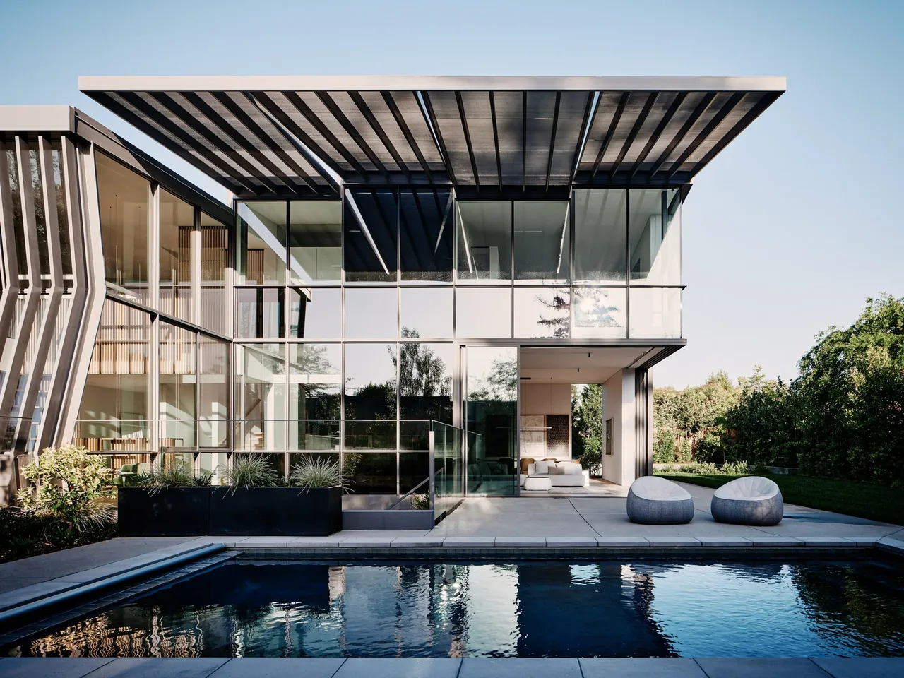 The WAVELET project features floor-to-ceiling glazing, a rectangular pool, and vertical slat facade elements.
