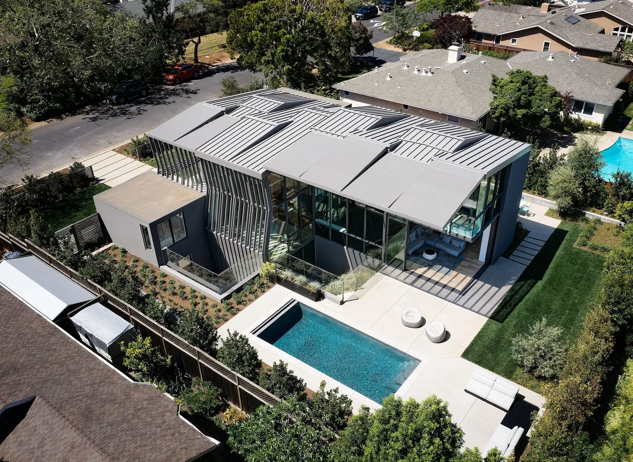 Modern house with vertical slat detail and a rectangular pool in a landscaped yard.