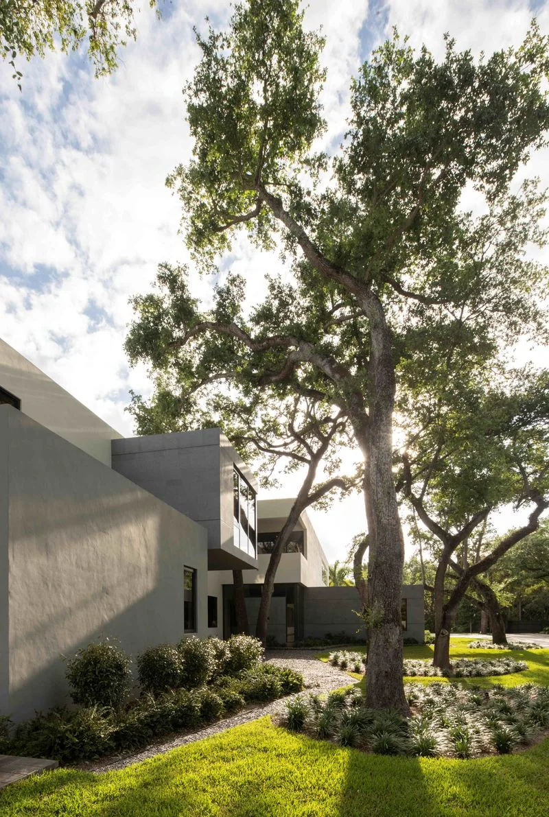 Contemporary residence exterior with landscaped garden and mature trees.