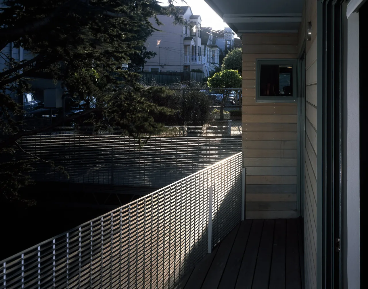 Balcony with metal mesh railing and wood siding at the Barnes Residence by Stanly Saitowitz.