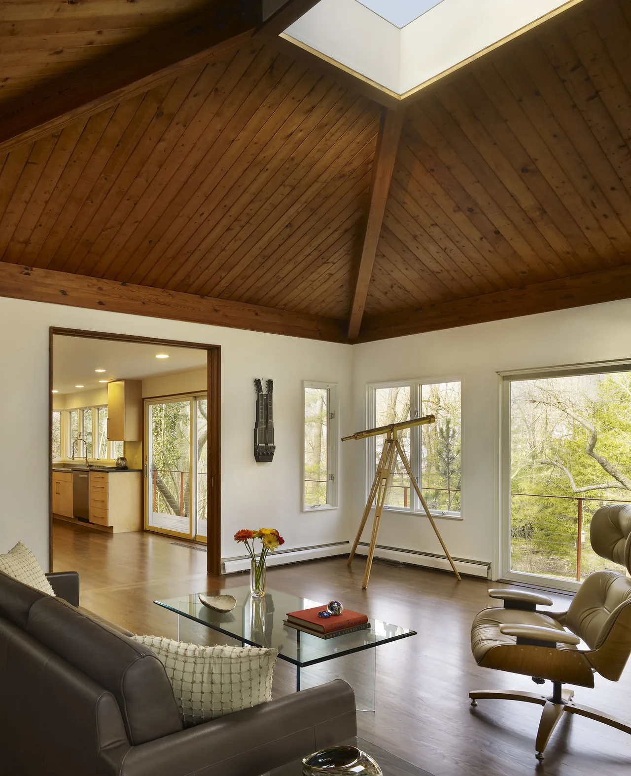 Living room with wooden vaulted ceiling and skylight providing natural light.