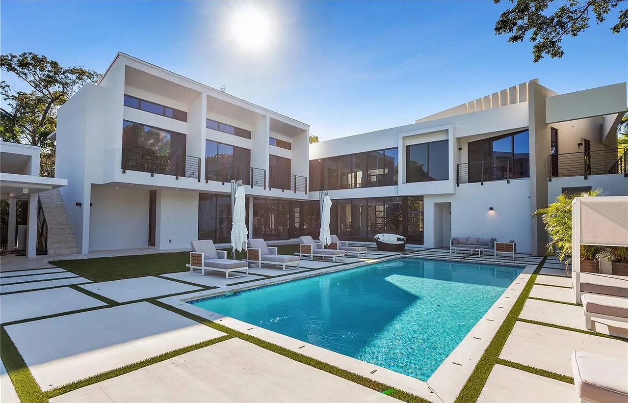 CASA MARIOLA features a modern two-story exterior with metal railing balconies and a rectangular outdoor pool.