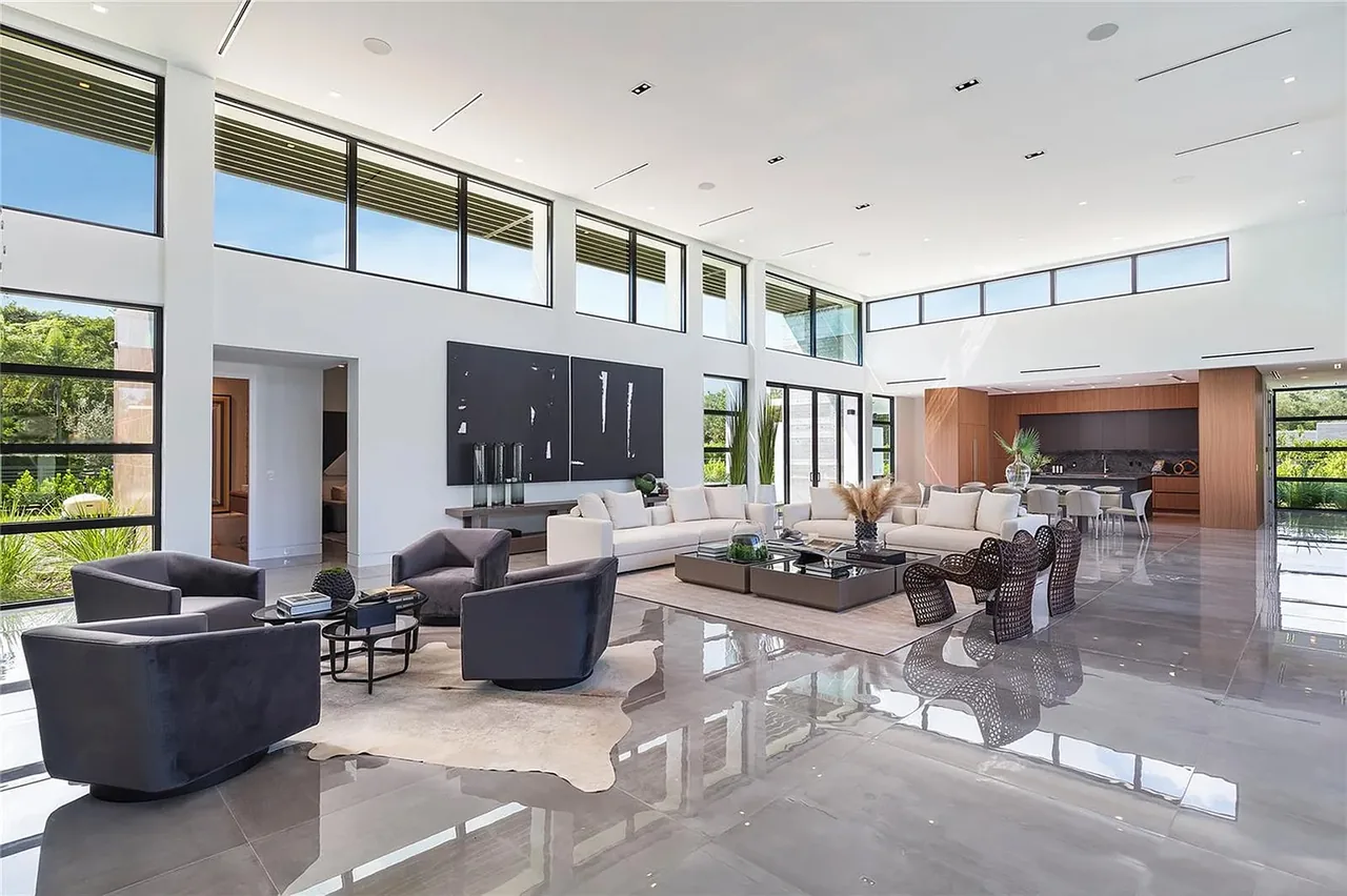 The living room features floor-to-ceiling windows, recessed lighting, and polished floor tiles for a bright open space.