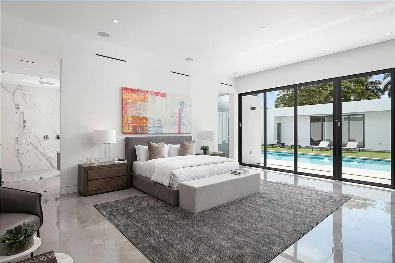 Bedroom with floor-to-ceiling sliding glass doors opening to a pool and courtyard in CASA BARSKY.