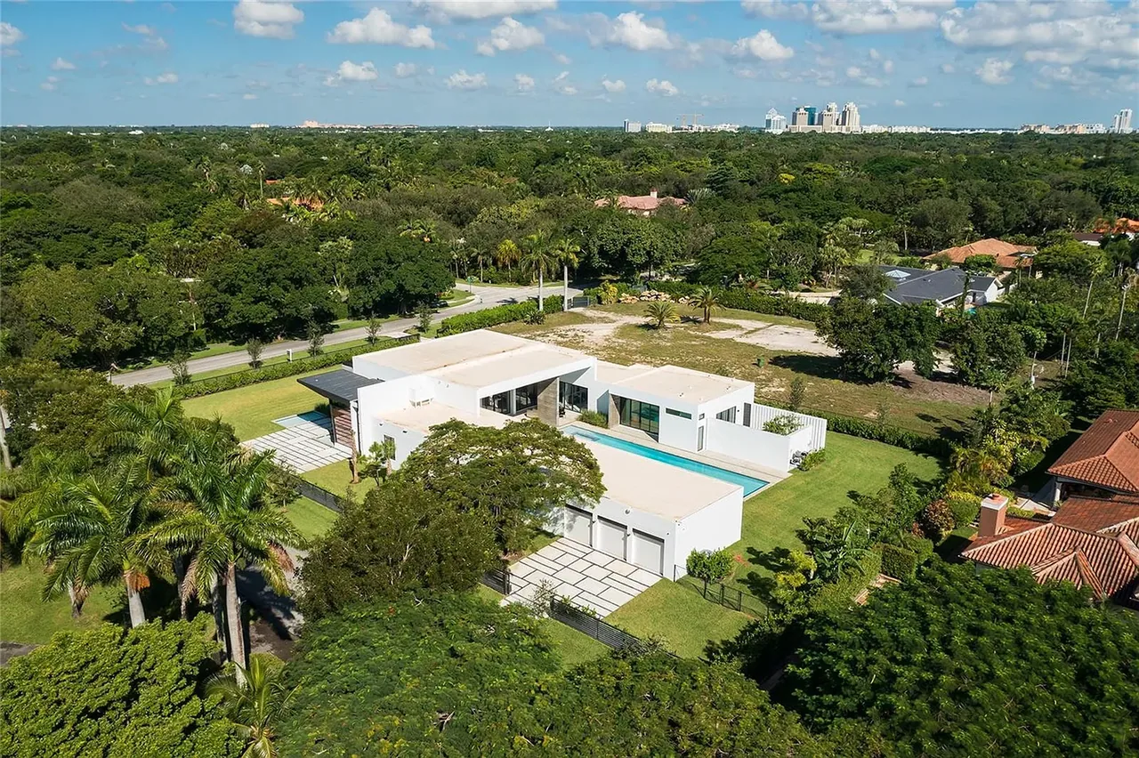 CASA BARSKY is a modern Miami home with a swimming pool and extensive green lawn on a large lot.
