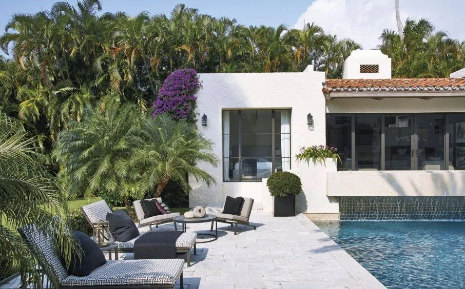 Venetian Island Residence features a pool patio with white stucco walls, terracotta roof tiles, and tropical landscaping.