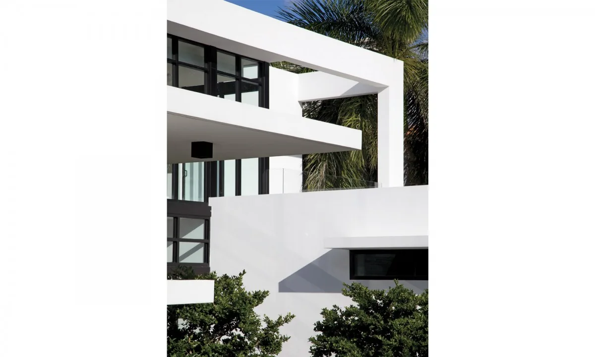 Modern architectural details showing white overhangs, black window frames, and surrounding plants.