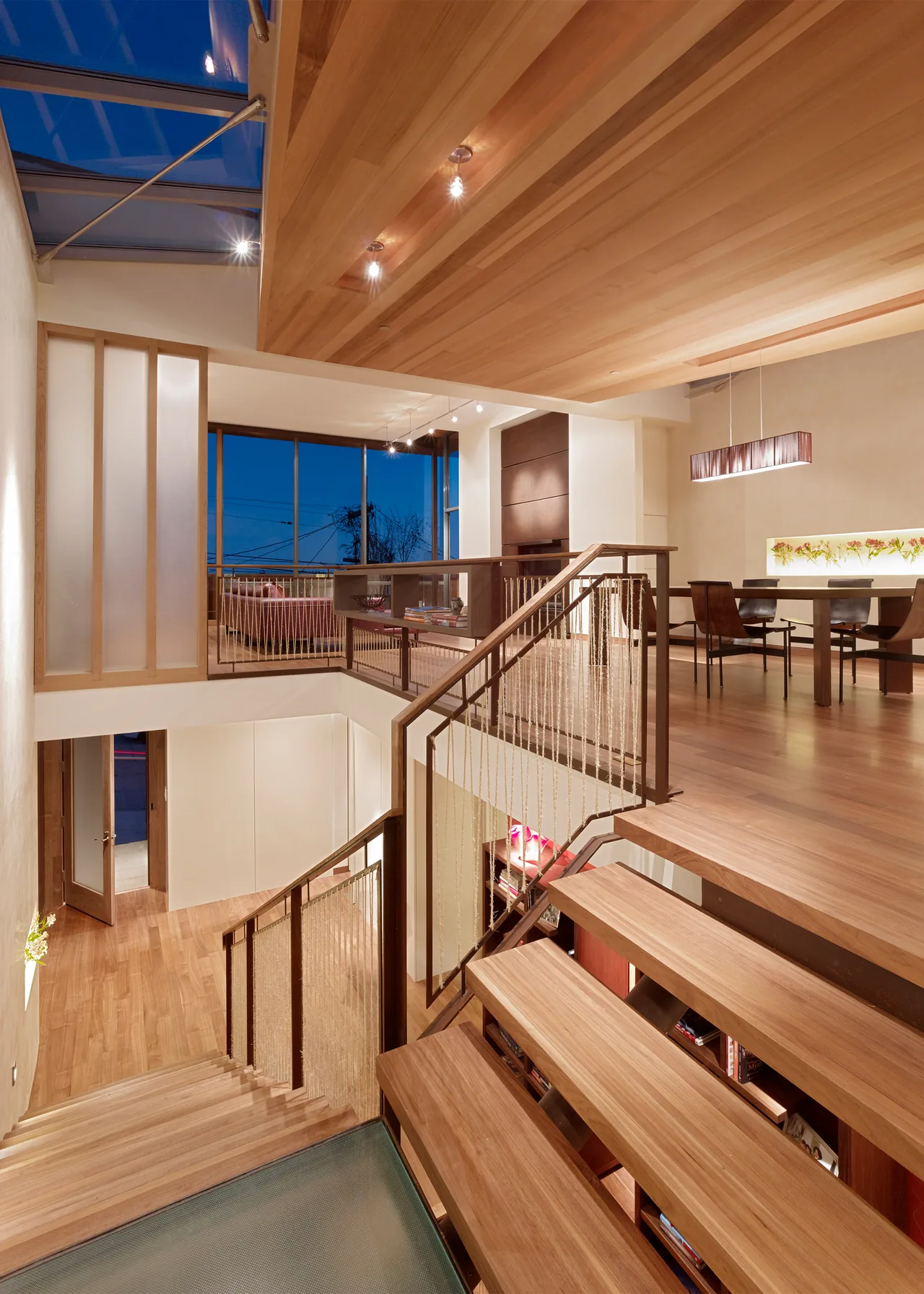 The Vessel features a multi-level interior with wood stairs, rope railing, and large corner windows at dusk.