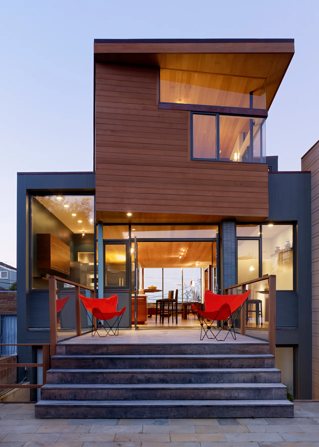 The Vessel by Kennerly Architecture features wood siding, large glazing, and a multi-level design visible at twilight.