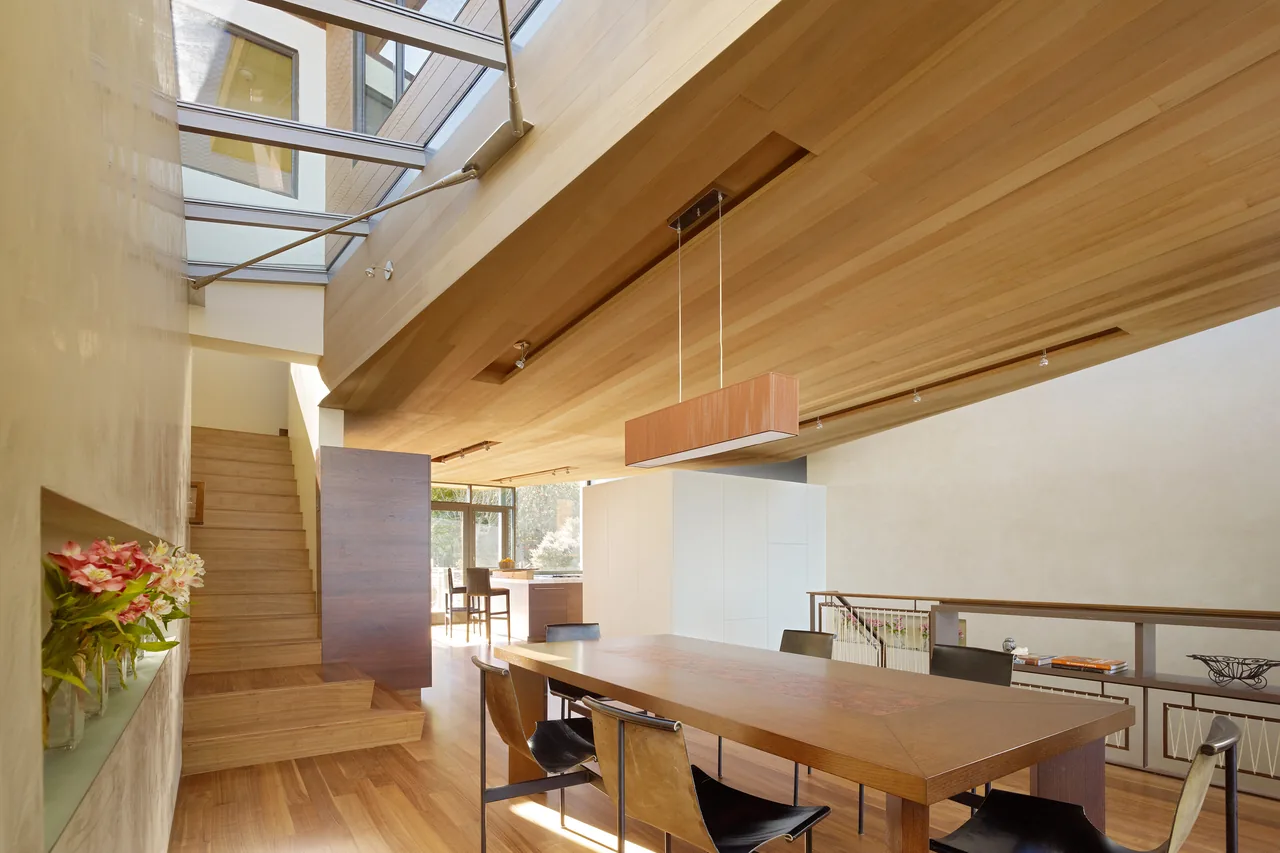 The Vessel features a wood-paneled ceiling and skylight above a dining area with wood flooring and modern furnishings.