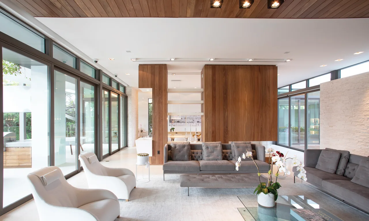 Living room featuring floor-to-ceiling glazing, wood panel ceiling, and wood partition with seating area.