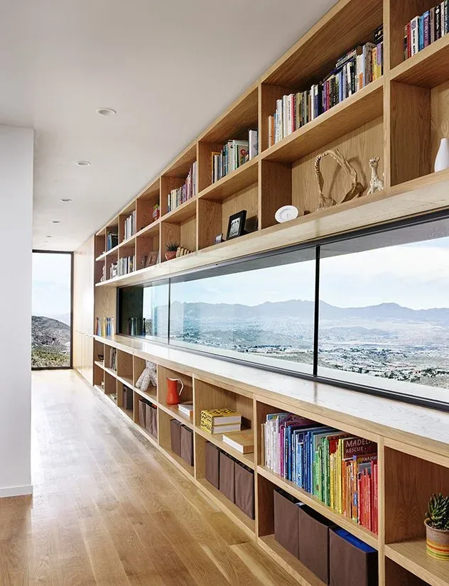 Hallway featuring built-in wood shelving and a panoramic window revealing a mountainous landscape.