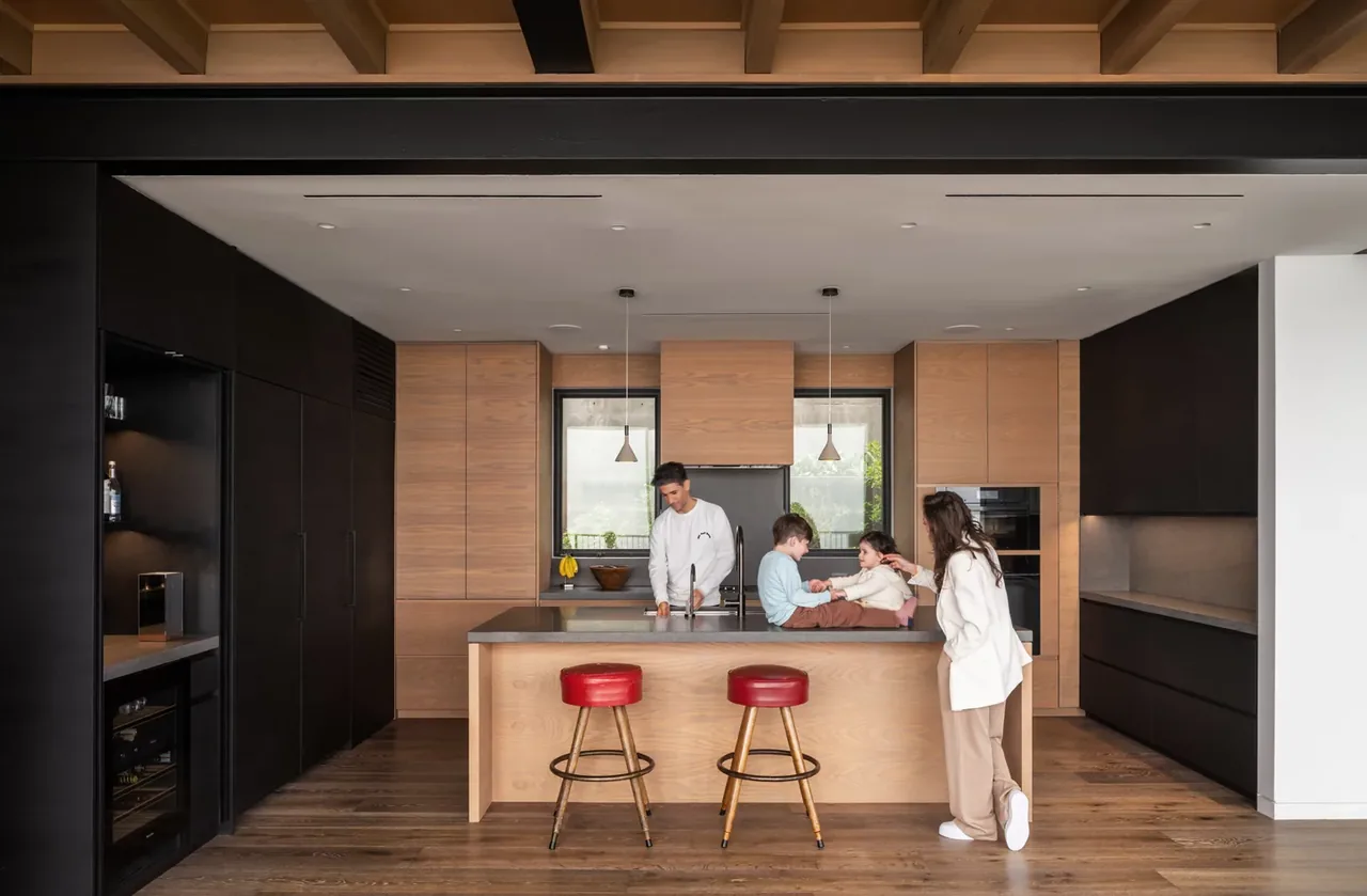 Interior view of a kitchen featuring wood cabinetry and an island with seating.