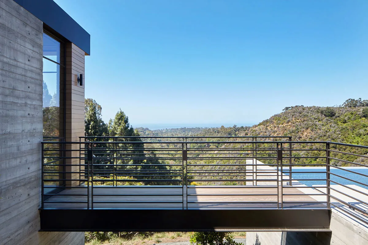 Outdoor metal railing frames scenic mountain views and a rectangular pool at the Sapire Residence.