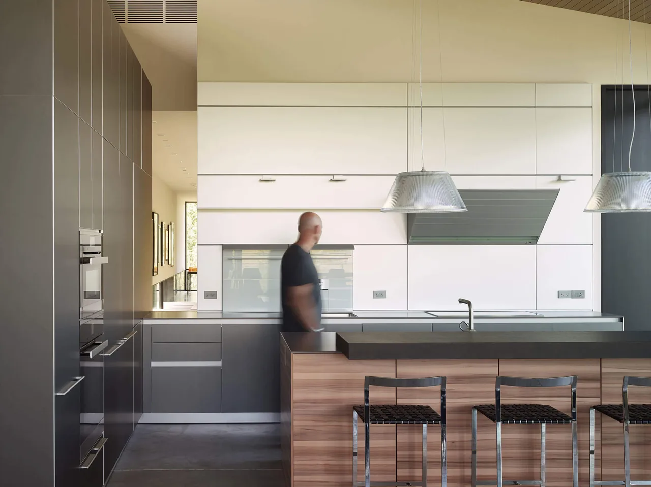 The Wyoming Residence kitchen has a clean, minimalist design with contrasting cabinetry and a large island for seating.