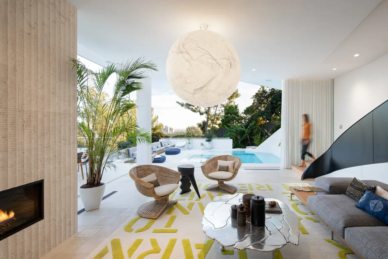 Living room with modern furnishings and an open view to an outdoor pool area.
