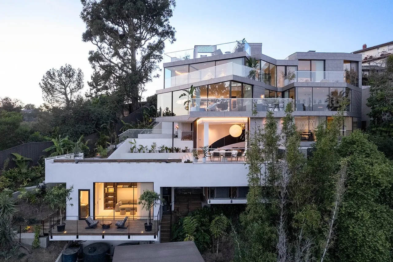 The Turning Point Residence features multi-level architecture with glass walls and terraces integrated with natural landscape.