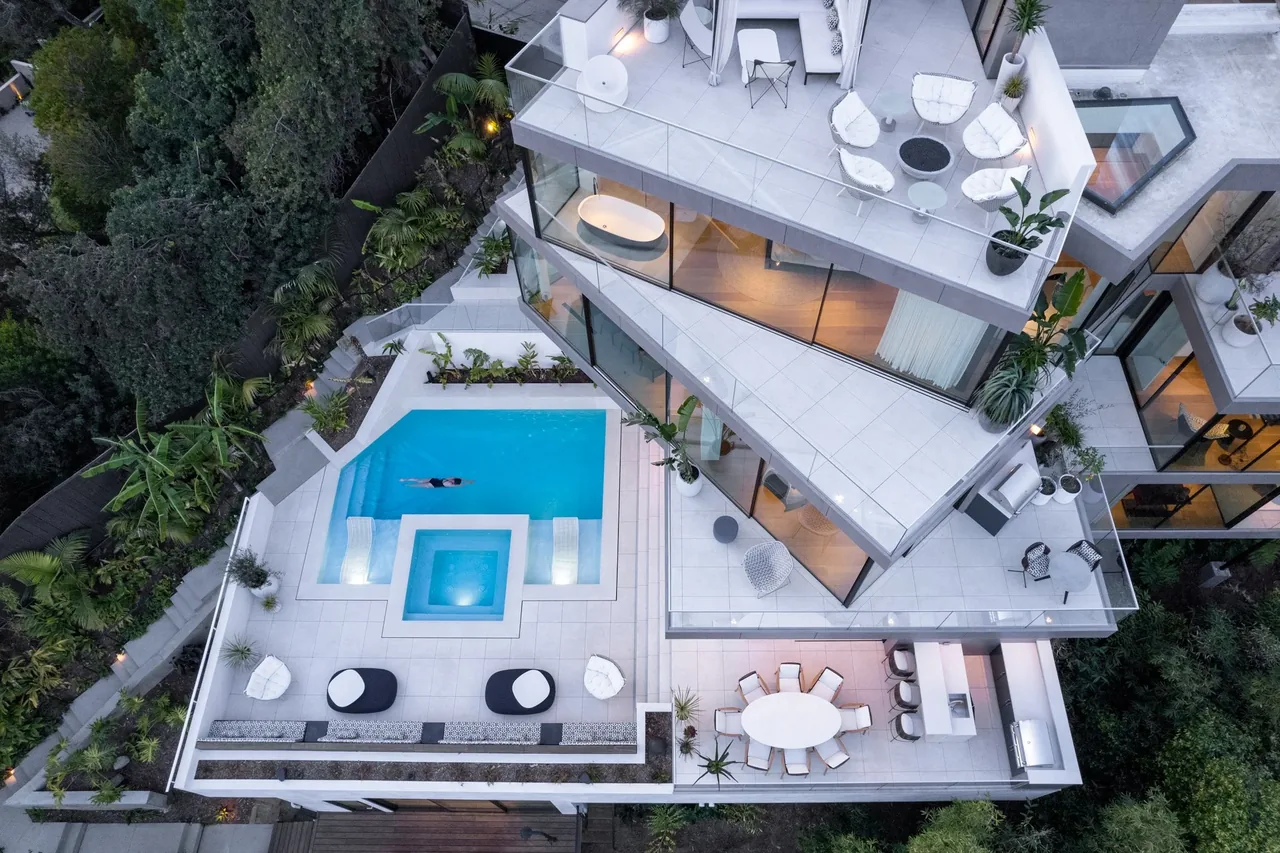 Overhead view of the Turning Point Residence showing multiple outdoor terraces, a pool, and extensive glass walls.