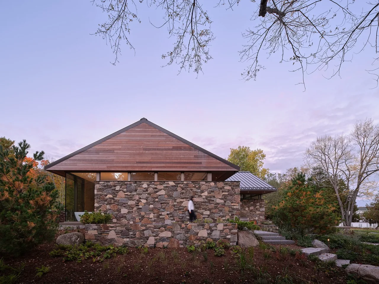 The Muskoka Cottage features a wood-paneled gable roof with stone cladding on the exterior walls.