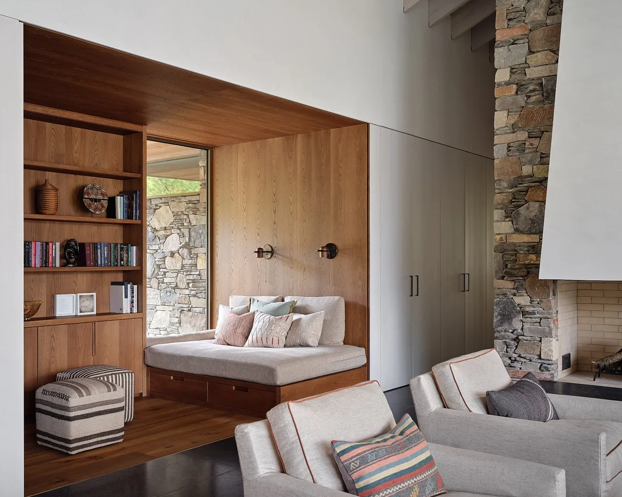 Living area features a wood-paneled built-in bench and a stone accent fireplace.