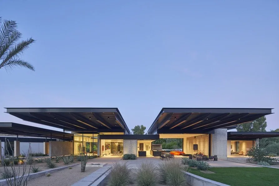 Camelback Residence features dramatic flat cantilevered roofs with concrete and glass walls amid desert landscaping.