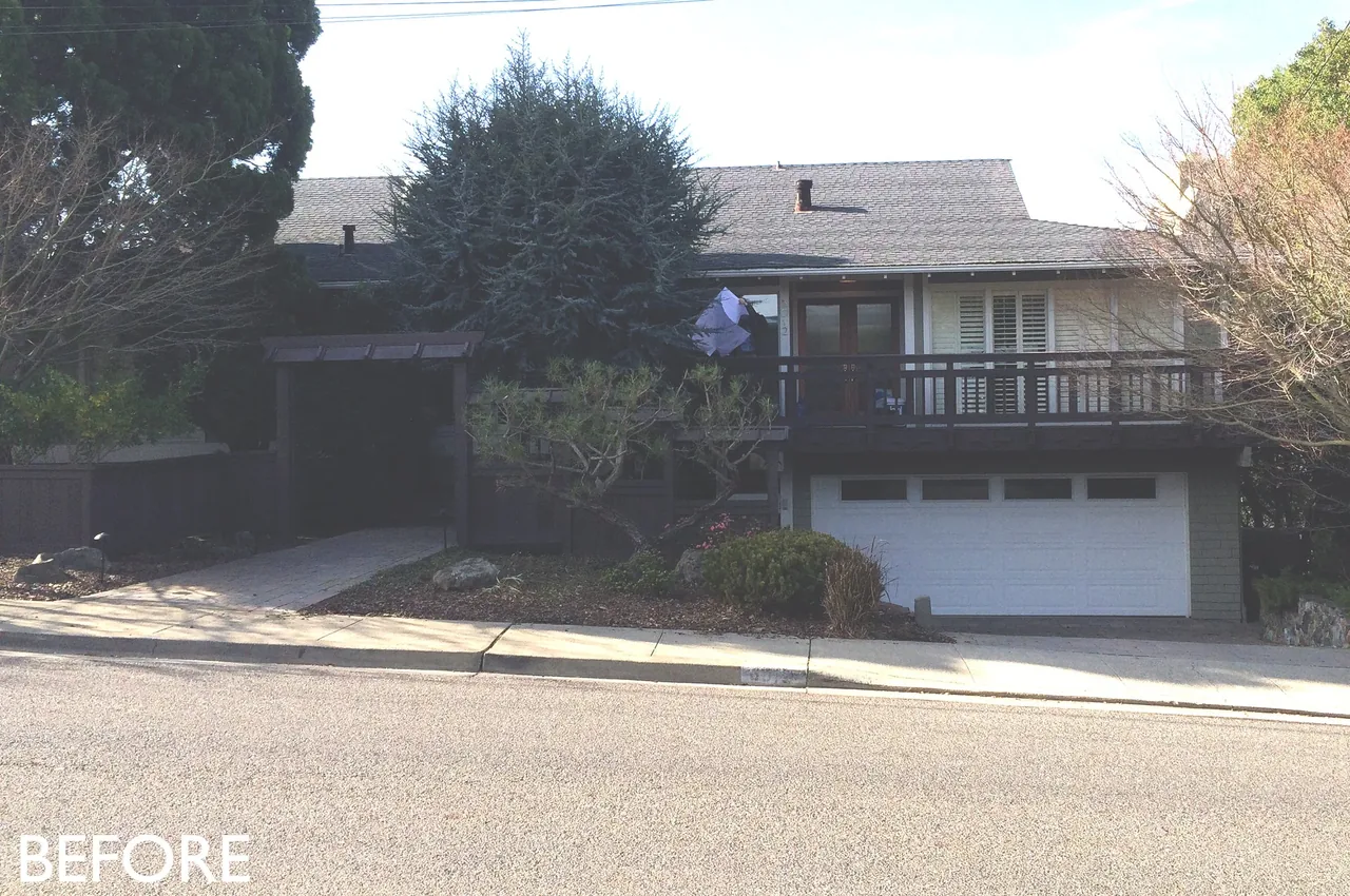 Exterior front view of a house showing a large balcony with horizontal railing and a garage below.