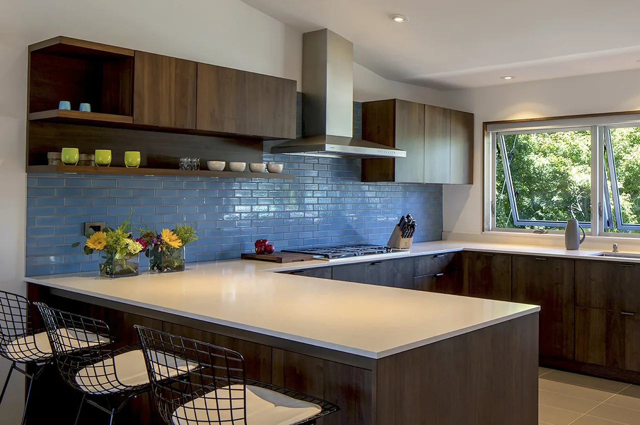 Kitchen features blue glazed tile backsplash, white quartz countertops, and dark wood cabinetry with a stainless steel range hood.