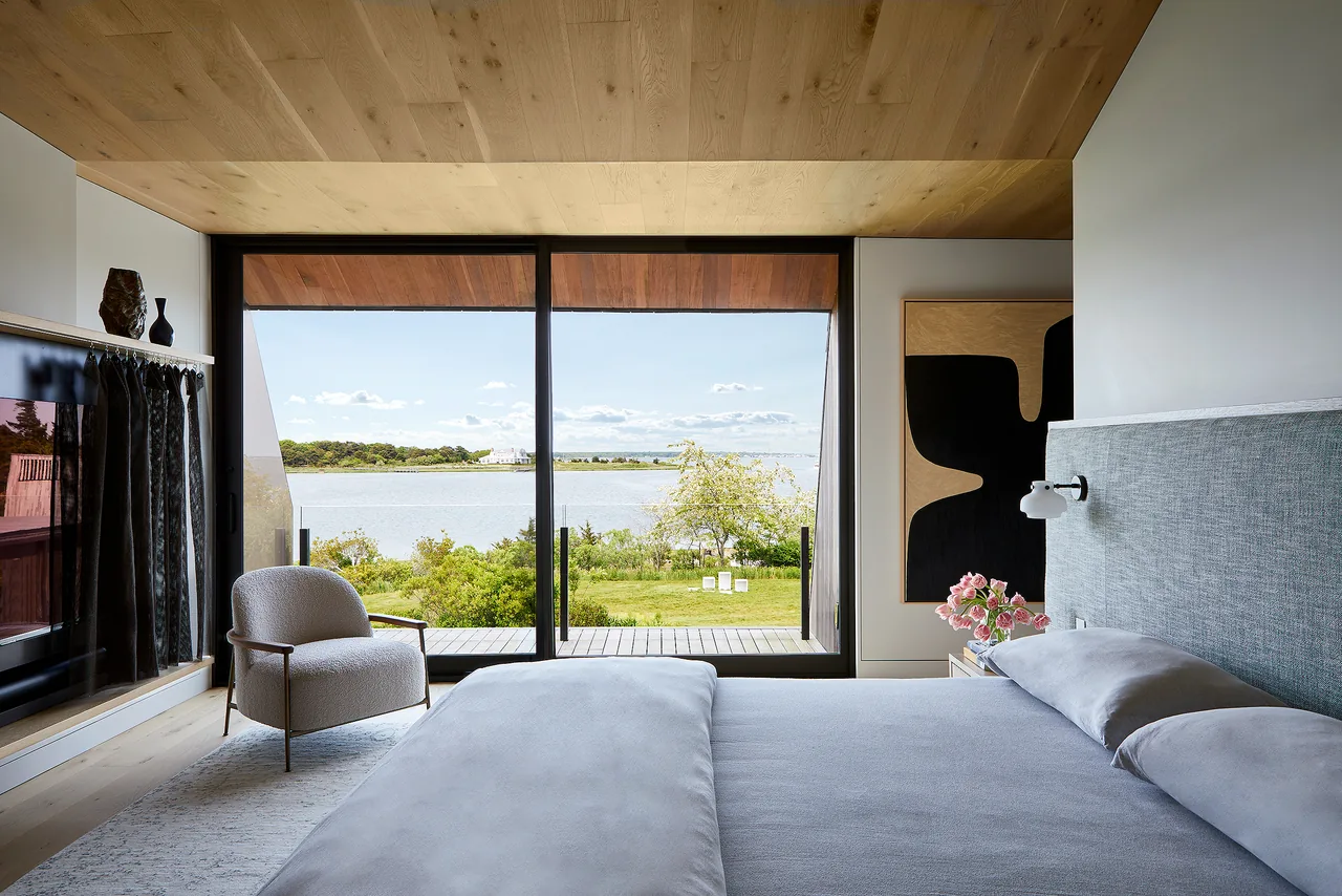 Bedroom featuring floor-to-ceiling sliding glass doors providing a view of the courtyard and water beyond.