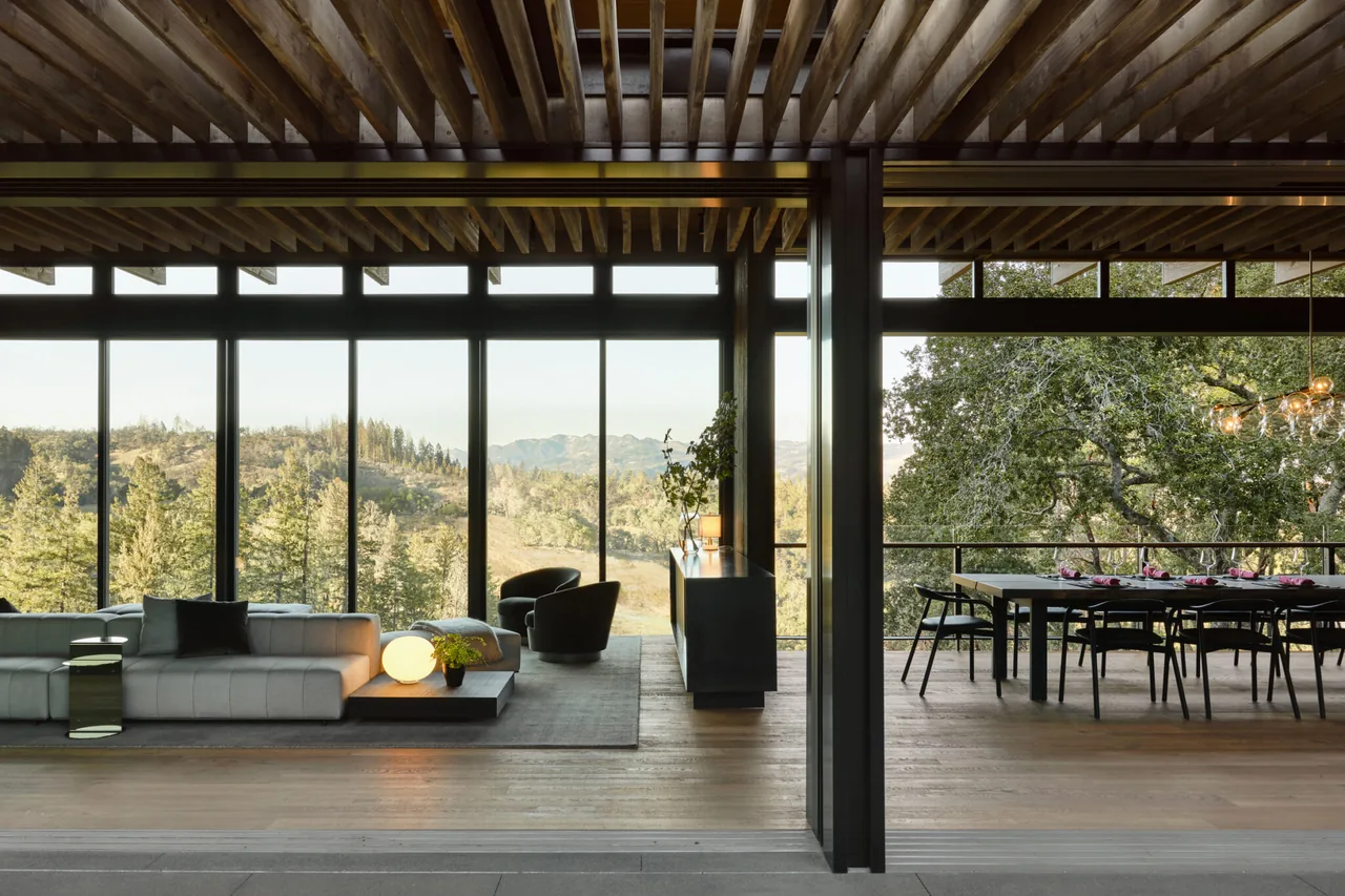 Living and dining areas of Trestle Residence by Aidlin Darling Design with extensive glazing showcasing natural scenery.