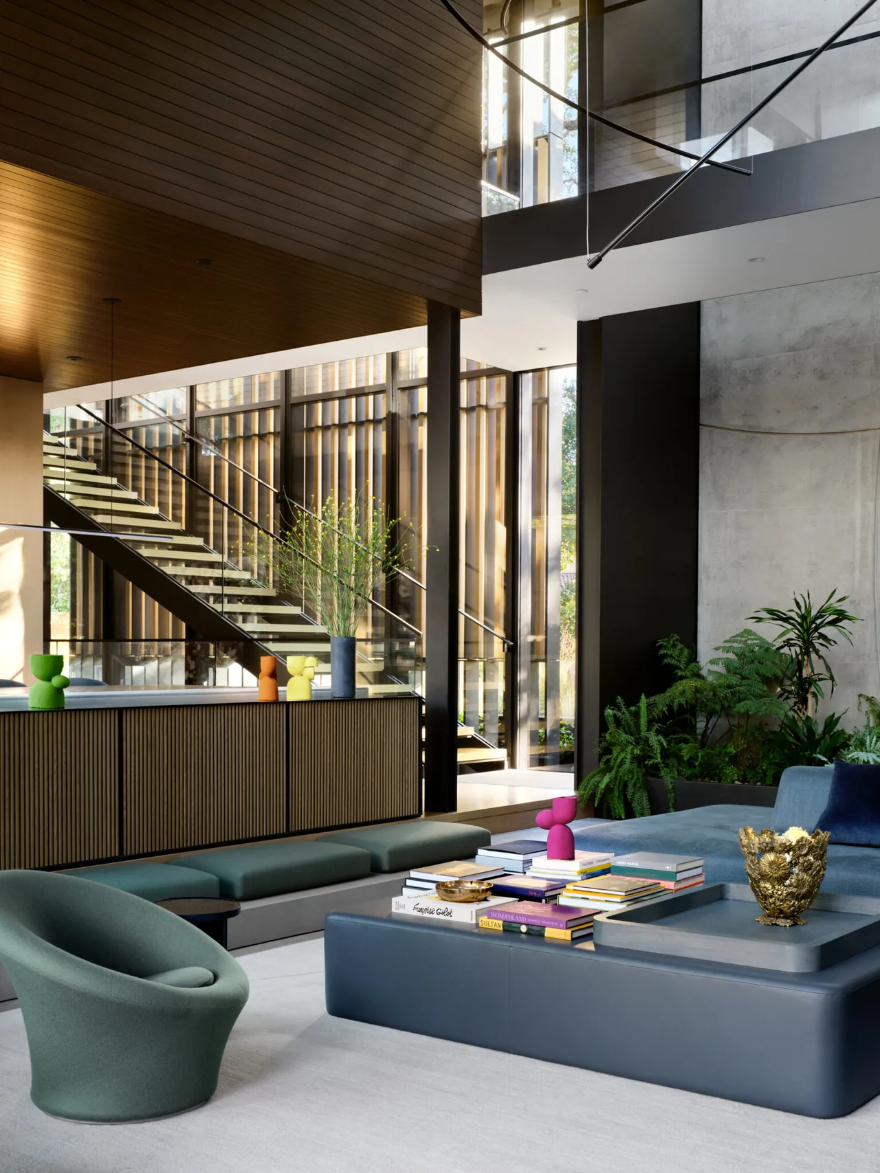 Living room interior of the L|J Residence featuring a floating staircase and floor-to-ceiling windows.