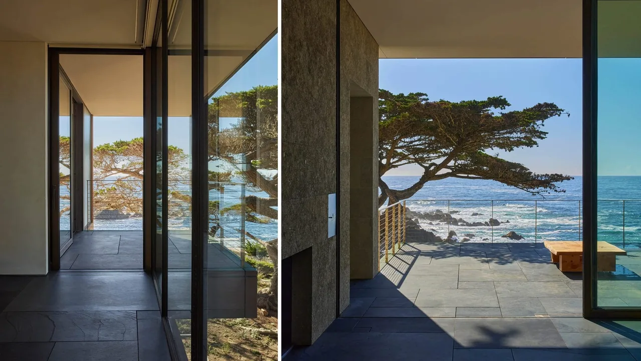 Interior corridor with floor-to-ceiling glass doors opening onto an oceanfront terrace with slate tile flooring.