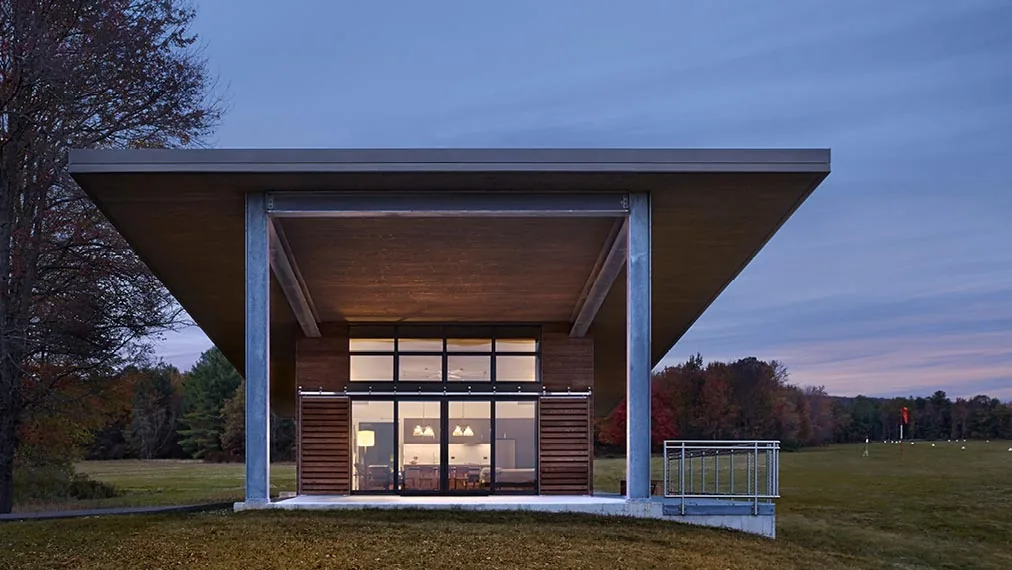 The Flying Dollar Residence features a deep flat roof overhang and extensive floor-to-ceiling windows on its exterior.