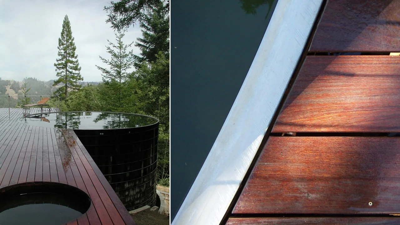Deck with circular water features and dark wood planks overlooks forested hillside.