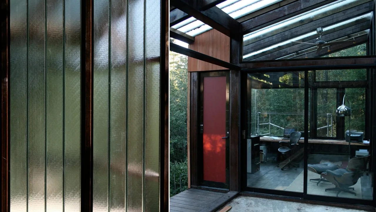 The Lundberg/Breuer Cabin features a glass curtain wall office space with wood framing and exposed beams.