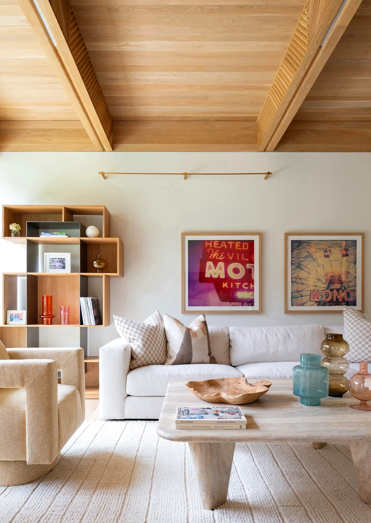 Living room with wood-paneled vaulted ceiling and modern furniture featuring a neutral color palette.