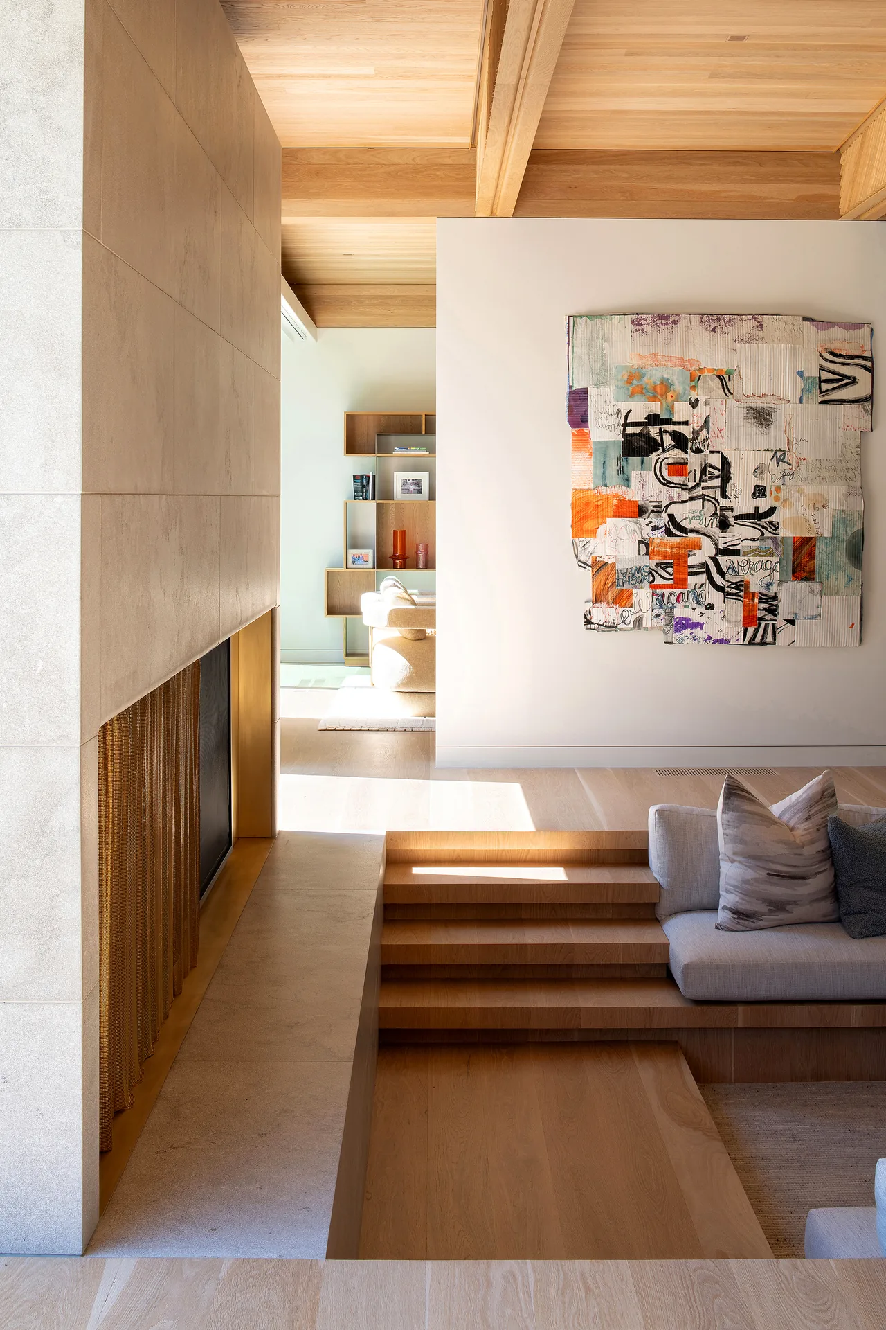 Sunken living room with tiled fireplace and built-in seating beneath wooden ceiling beams.