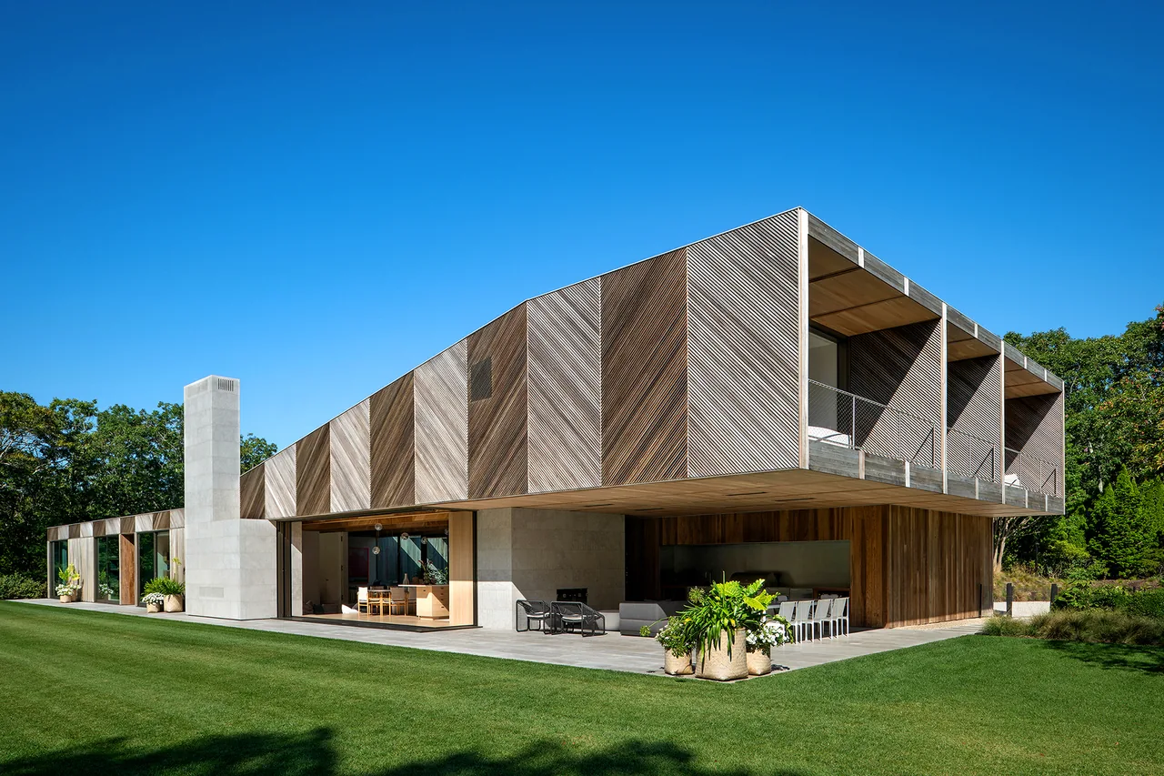 Modern house with wood slatted cantilevered upper floor and concrete chimney
