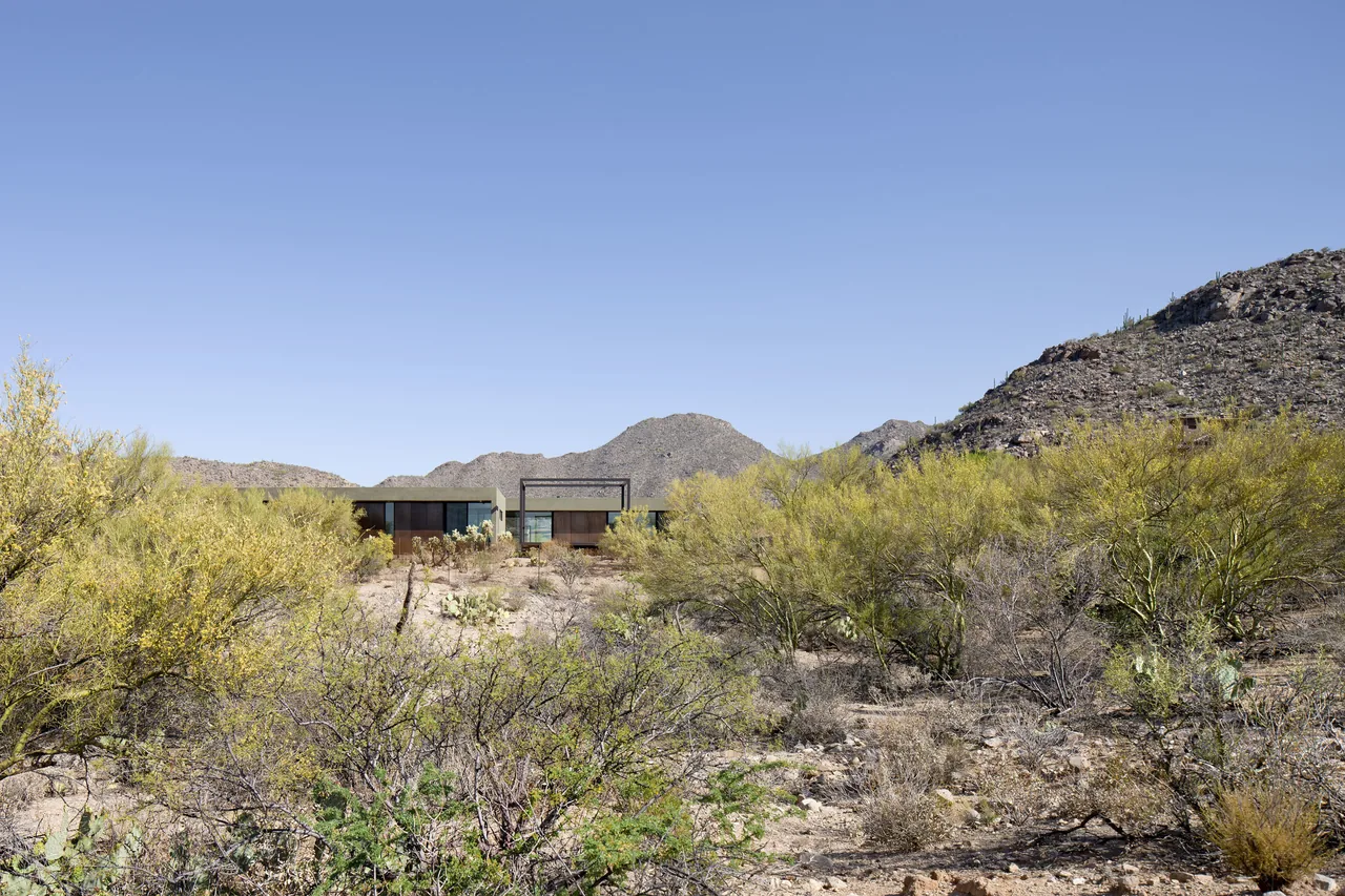 The Ibarra Rosano house features rusted steel and glass facades with a flat roof, nestled in the desert landscape near Phoenix.