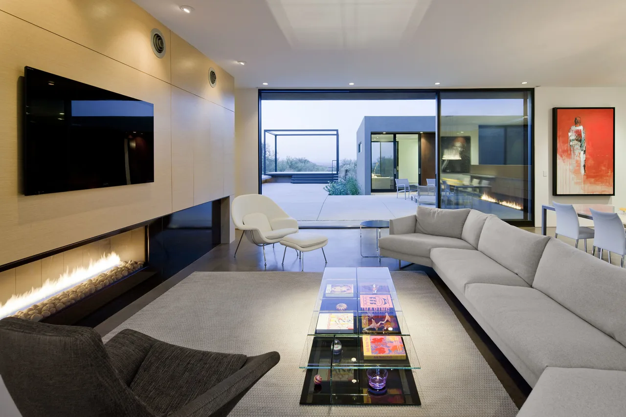Living room featuring a linear fireplace, floor-to-ceiling windows, and seamless indoor-outdoor connection to a patio.