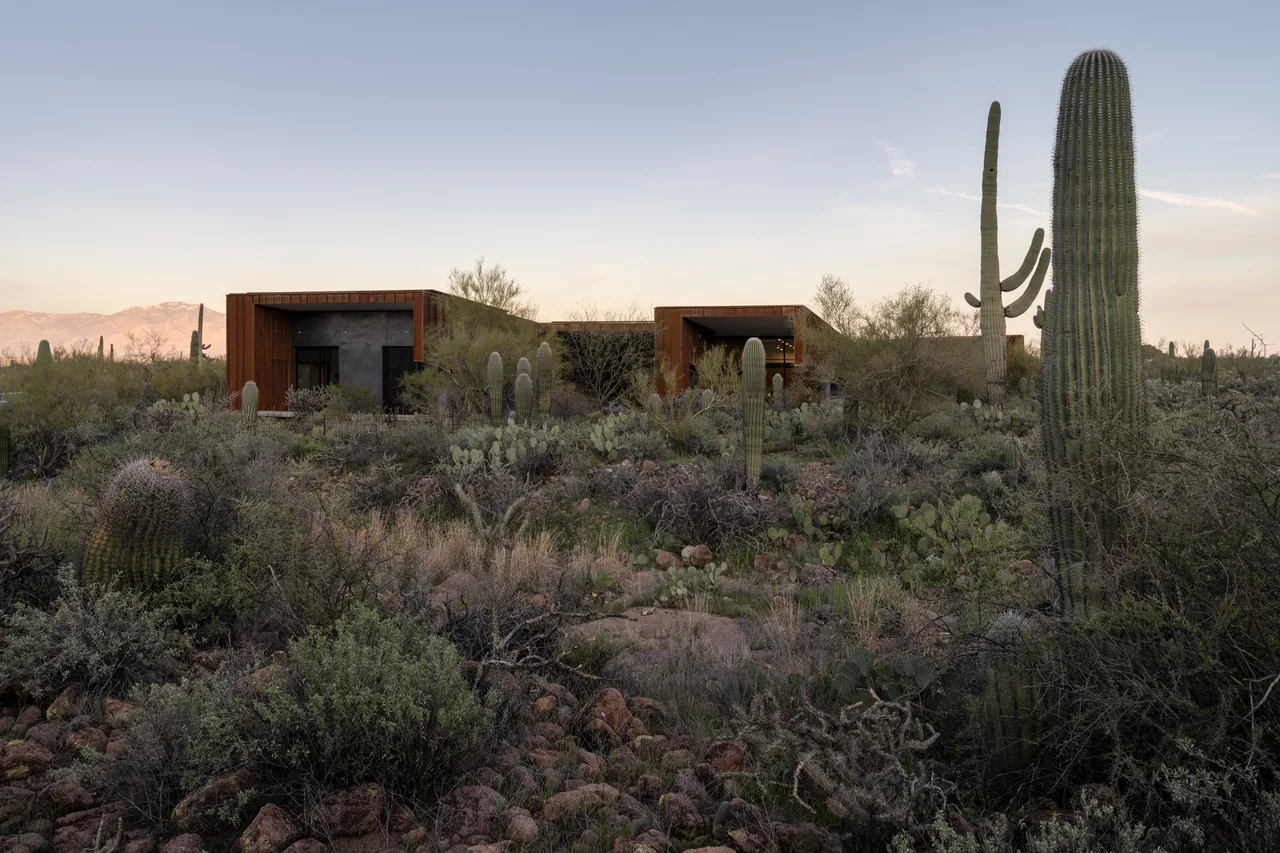 The TS Falls West Residence features a modern design with rust-colored materials amid a desert landscape in Phoenix.