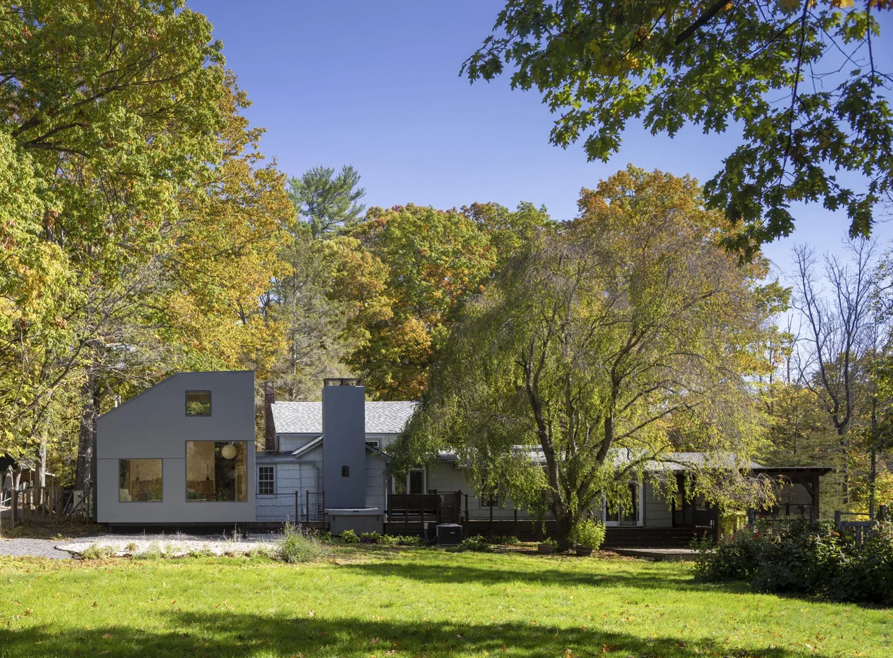 Catskill Creek Addition features a modern exterior addition with large windows next to an older traditional house.