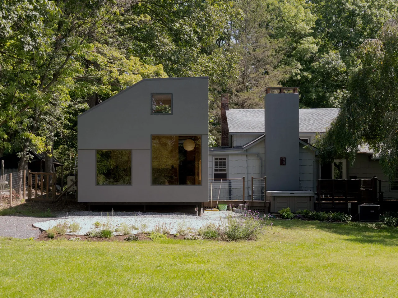 The Catskill Creek Addition features a modern two-story addition with an asymmetrical roofline and large rectangular windows.