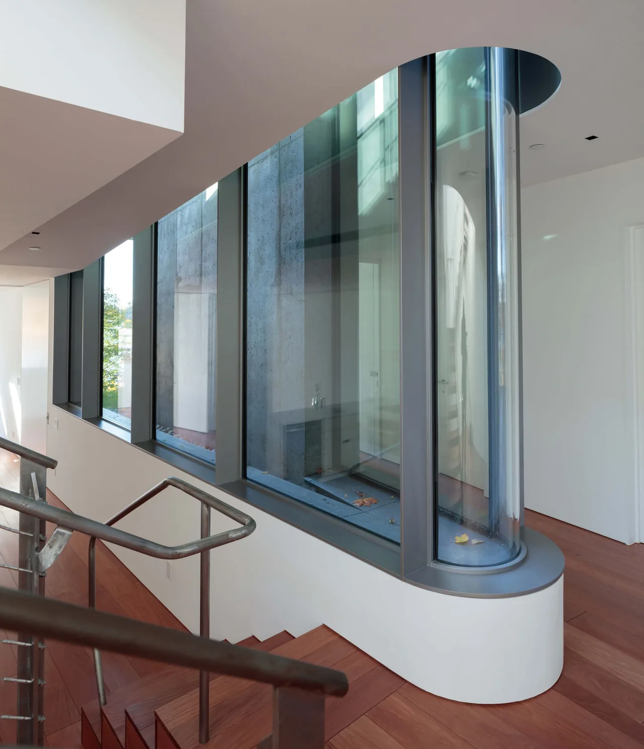 The Horizon House features a distinctive curved vertical glass window visible from its staircase hallway.