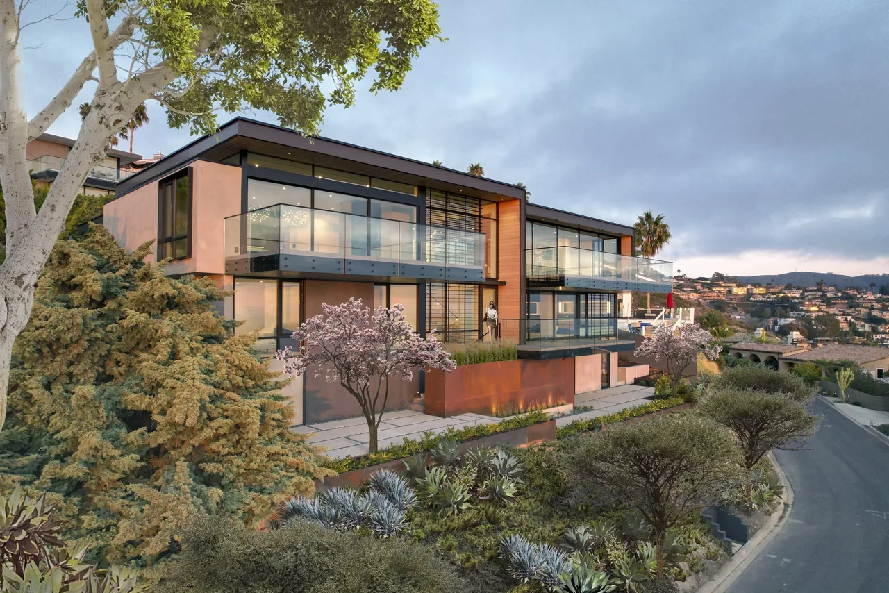 The Anacapa House features floor-to-ceiling glazing and glass balconies with black window frames on two stories.