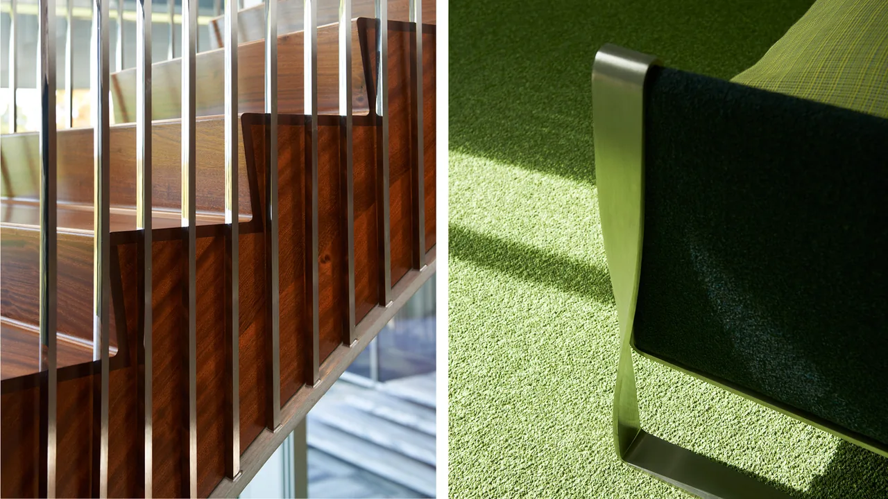 Wooden staircase with vertical metal rods and a metal-framed chair on green carpet in interior space.