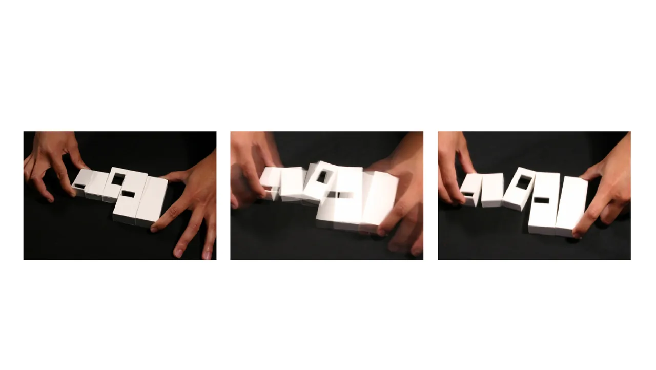 Hands adjusting a small white conceptual architectural model of a residential layout.