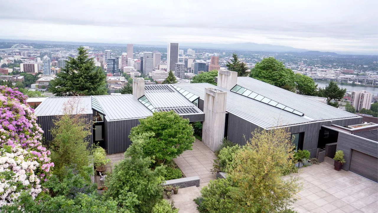Portland Heights Residence features metal roofing and concrete chimneys with vertical wood siding, overlooking Portland city.
