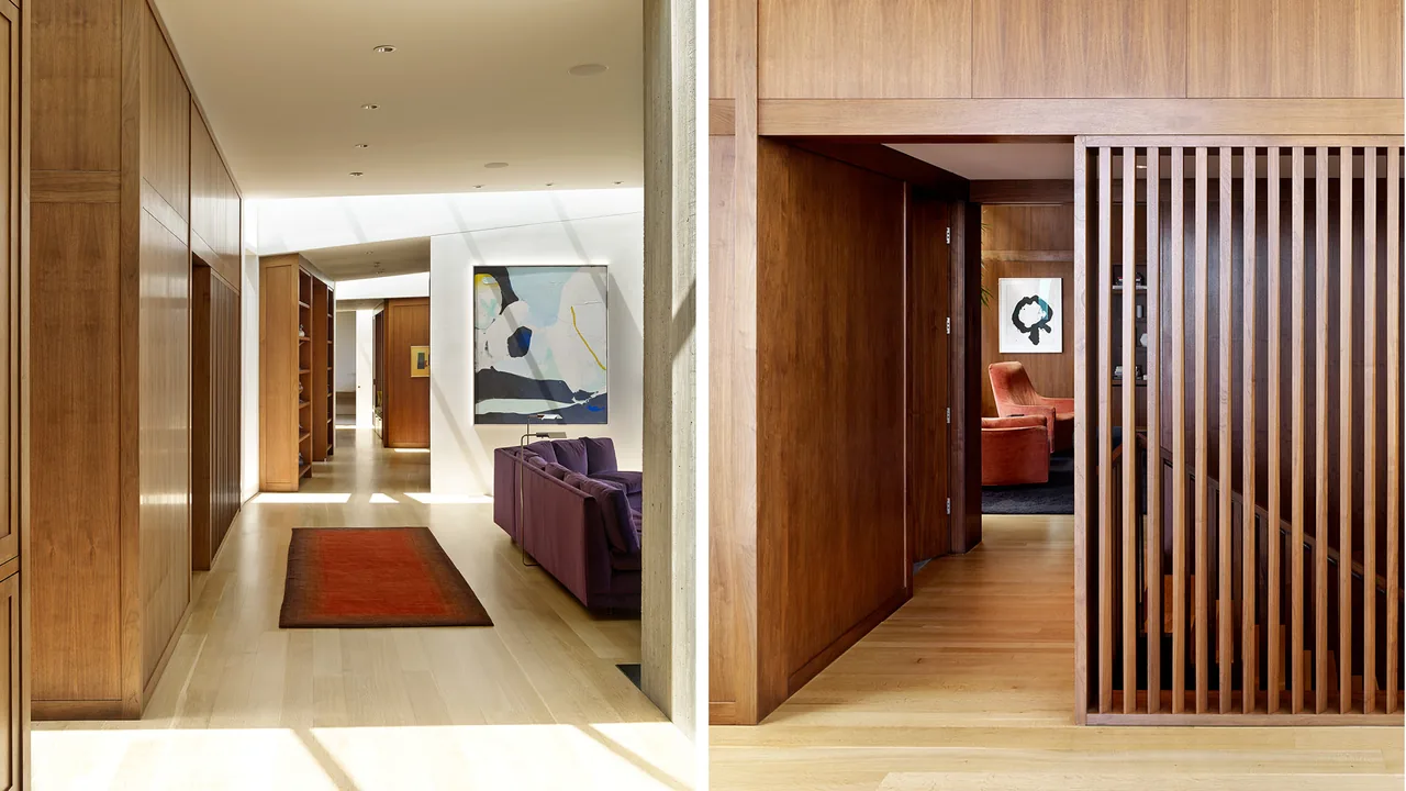 Interior hallway of Portland Heights Residence, with wood-paneled walls, light wood floors, artwork, and natural light from skylights.